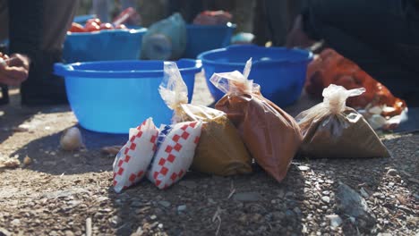 refugees preparing food cutting vegetables outdoors sunshine spices in foreground