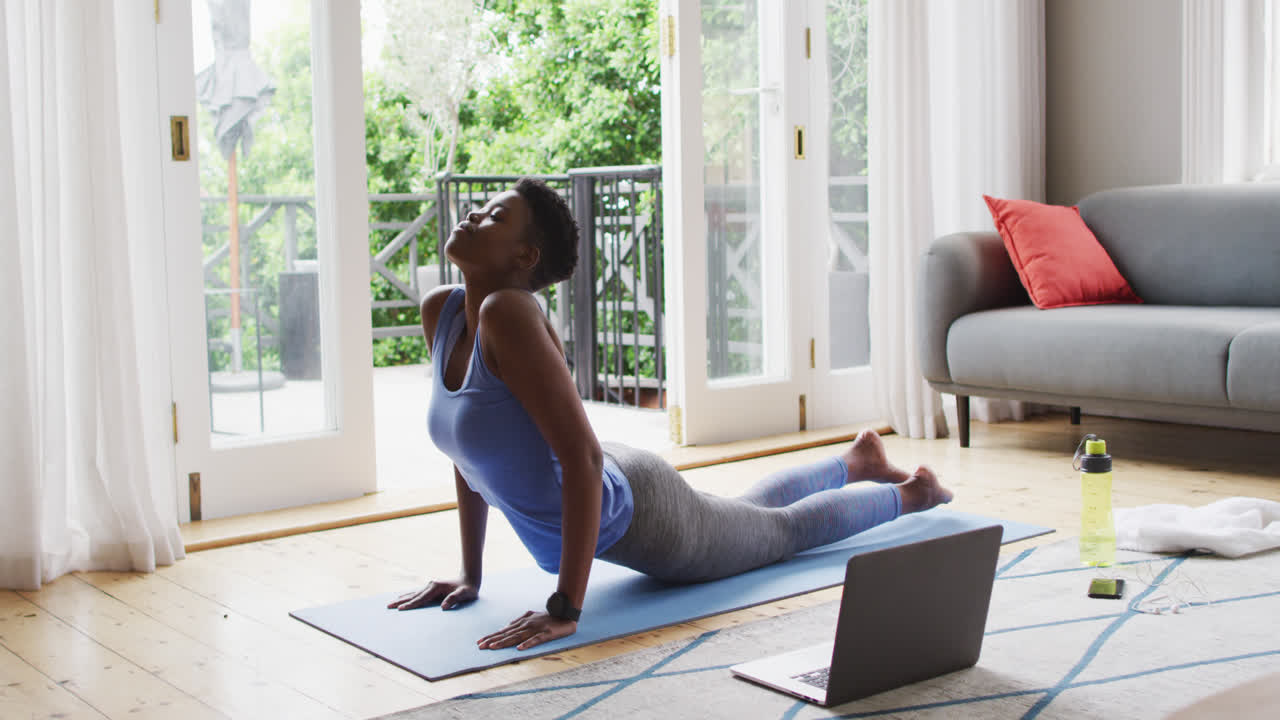 African american woman performing stretching exercise at home