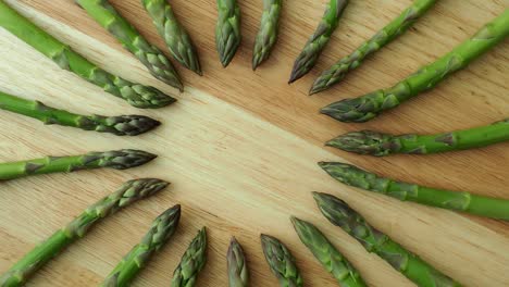 los tallos crudos de espárragos de jardín. vegetales de primavera verdes frescos sobre un fondo de madera. (asparagus officinalis).