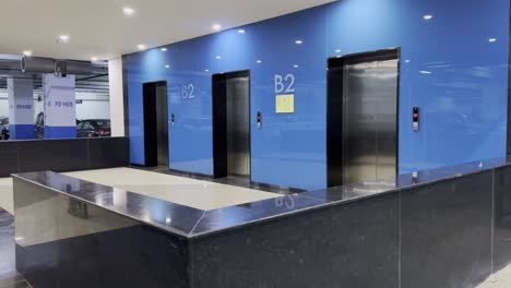 close-up of a lift (or elevator) in a b2 basement at a mall or airport showing the elevator doors, the floor indicator above the doors