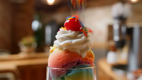 vibrant rainbow ice cream sundae with whipped cream and cherry