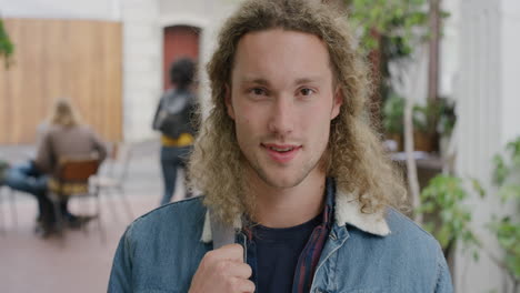 portrait of handsome young man smiling confident looking at camera enjoying independent student lifestyle in urban outdoors campus background