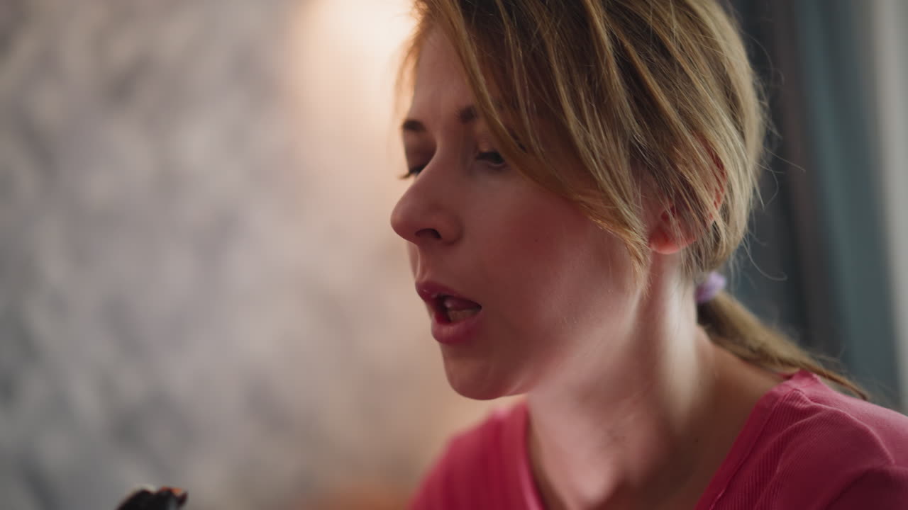Business lady with hair tied in purple ribbon eating sushi with chopstick while on vacation in hotel room showing relaxed moment in soft blur background