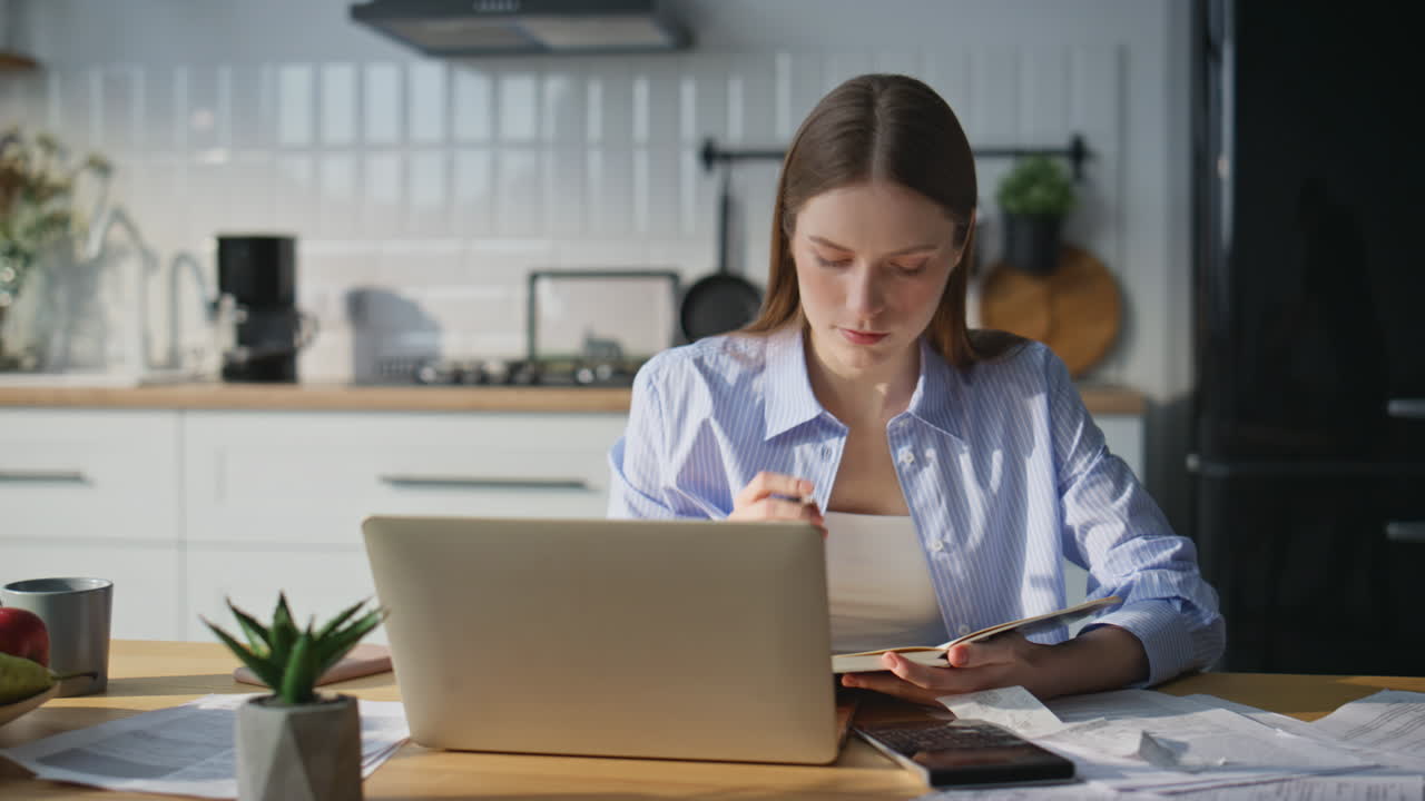 Online student making notes listening webinar on laptop at home closeup
