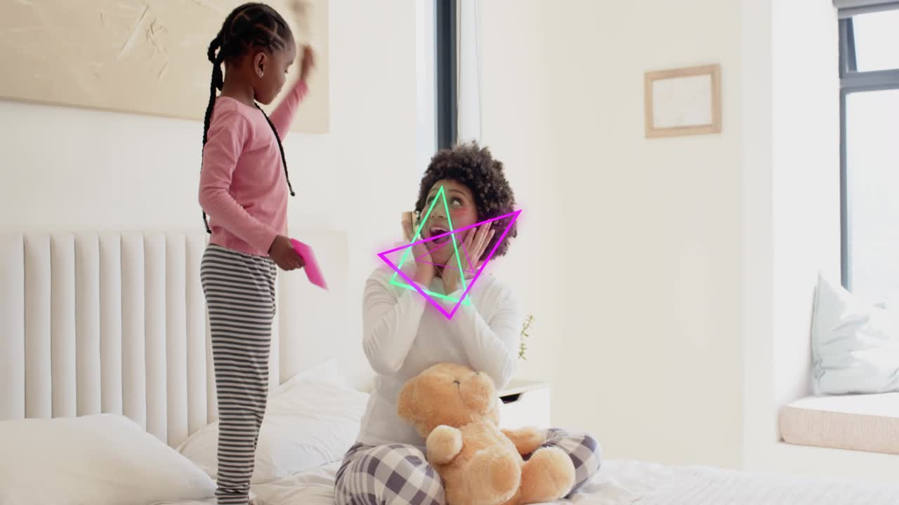Child raising pink comb on bed, playfully brushing mom's hair, neon triangles overlaying family