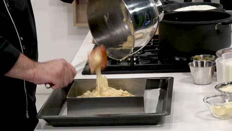 chef demonstrates precise cake batter preparation in a contemporary kitchen. ingredients are mixed methodically, showcasing essential techniques for bakers