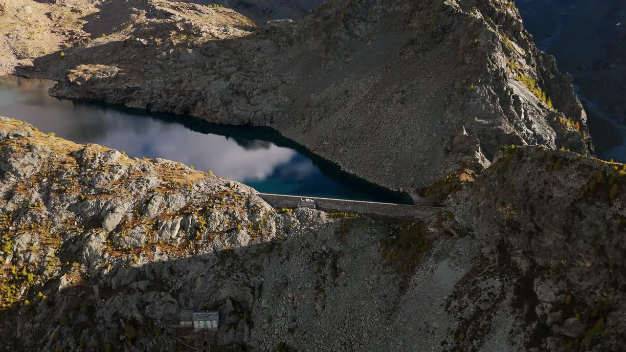 Aerial view of the Enel weir at Lago Pirola, nestled in the scenic landscape of Valmalenco, Lombardy