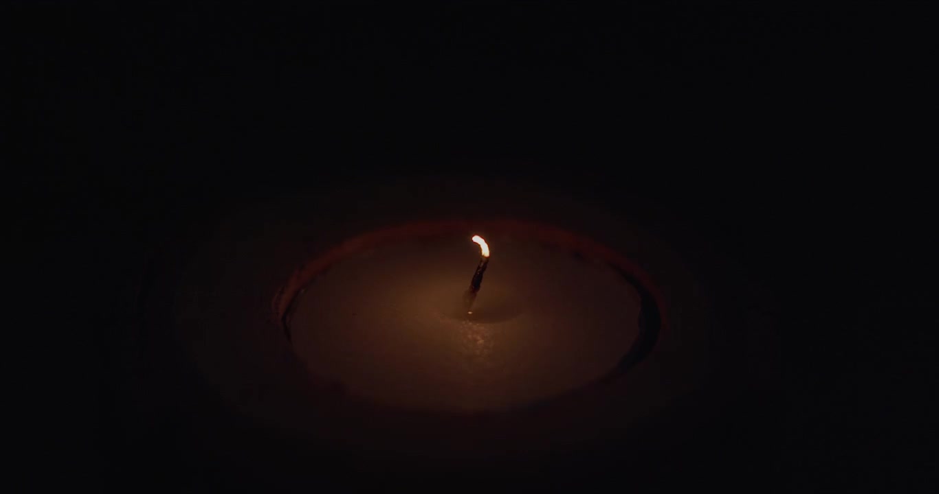 Una candela che viene spenta al buio