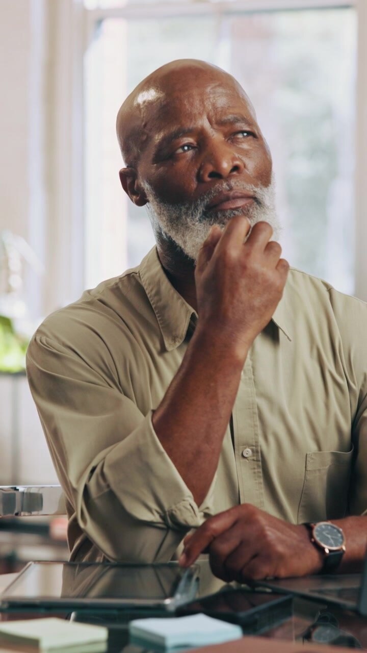 Thoughtful Senior Man Sitting at Desk in Office