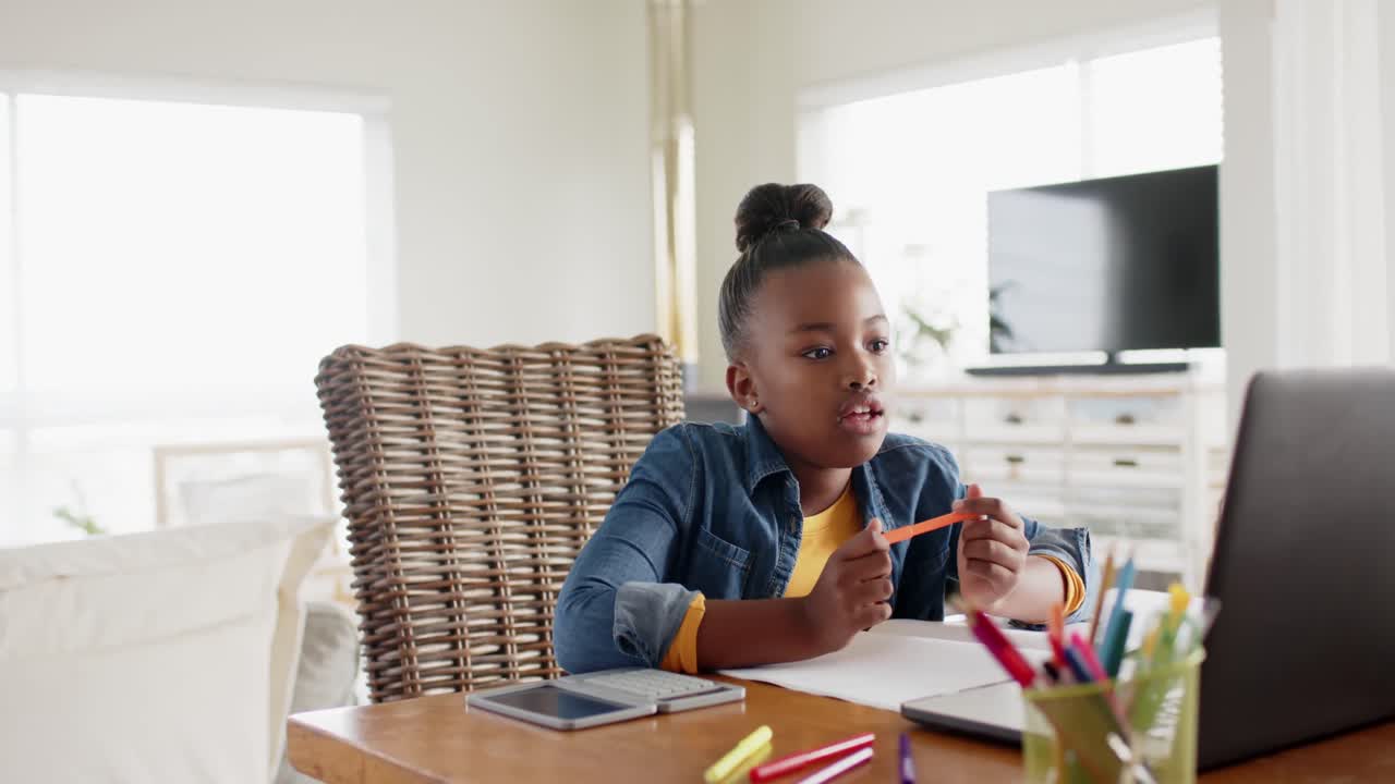 Busy unaltered african american girl using laptop for online lesson, slow motion