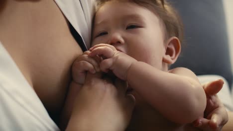 mom playing with asian toddler just right after breastfeeding.