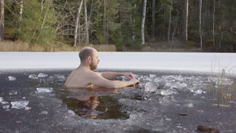 Cámara-Lenta:-Un-Bañista-De-Hielo-Masculino-Se-Sienta-En-El-Agua-Helada-Para-Comenzar