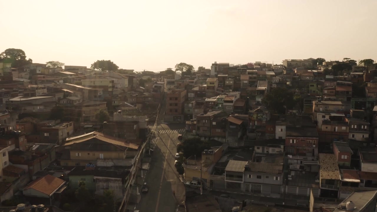 Gün batımında bir tepede yer alan eski binalara sahip ünlü Inferninho Favela'sının havadan genel görünümü.
