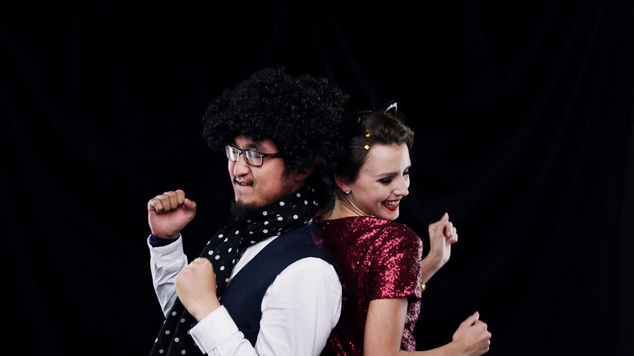 pareja de raza mixta bailando en una cabina de fotos en cámara lenta de la fiesta