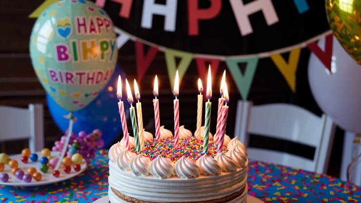 Colorful birthday scene with a cake and lit candles, captured at eye level