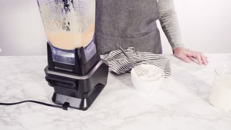 mixing ingredient in an electric blender to make the crepes batter.