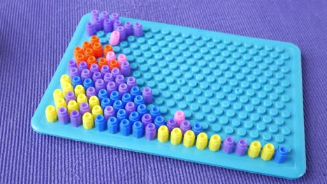 colorful beading craft on pegboard