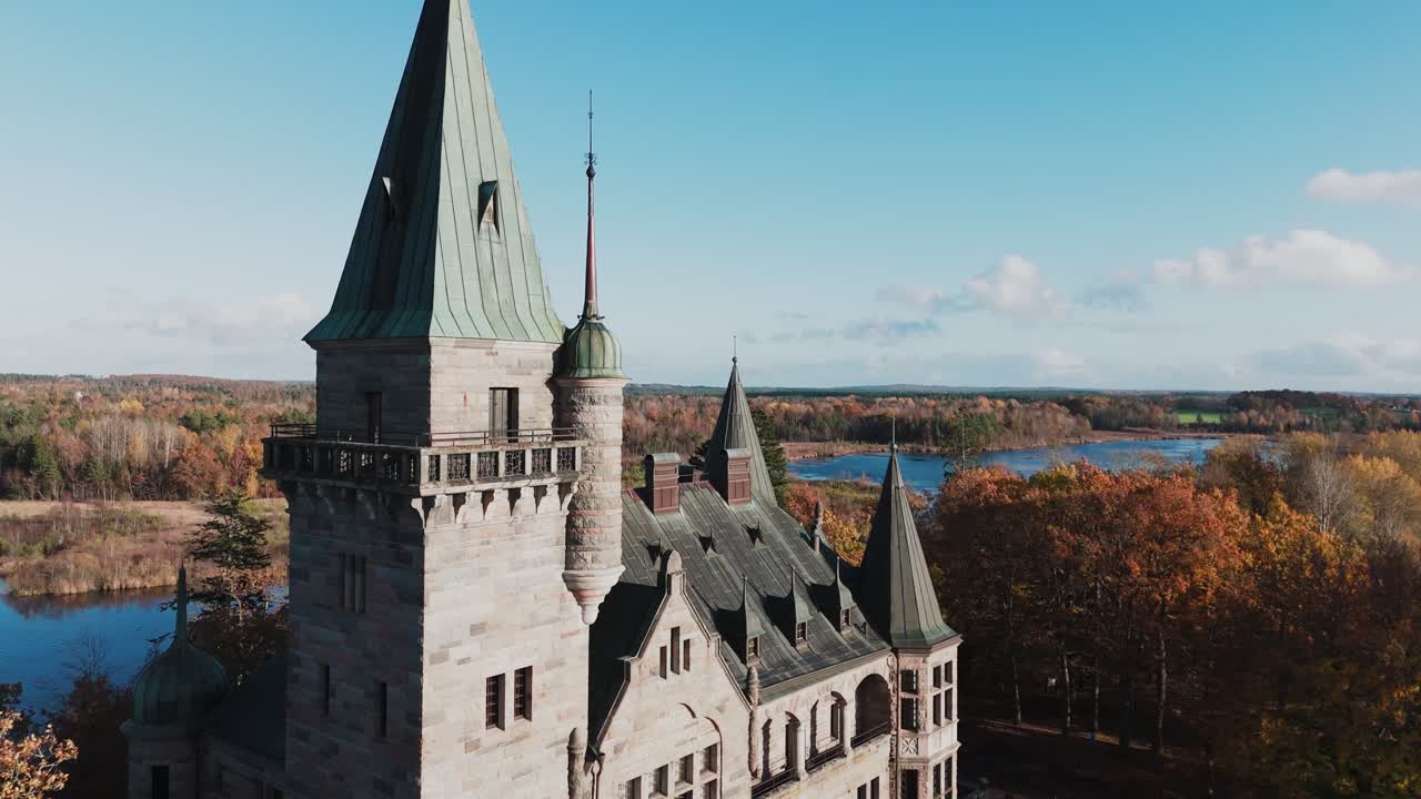 Tracking shot towards Teleborg Castle in Växjo, Sweden, Fall, Orange and Yellow Leafs, Flying past the castle, revealing the forest