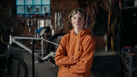 la précision de la fabrication moderne: l'expertise d'un adolescent. un adolescent en lunettes de protection et un sweatshirt orange pose contre le