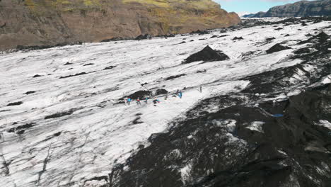 Aerial-parallax-around-photographers-shooting-on-surface-of-Icelandic-glacier