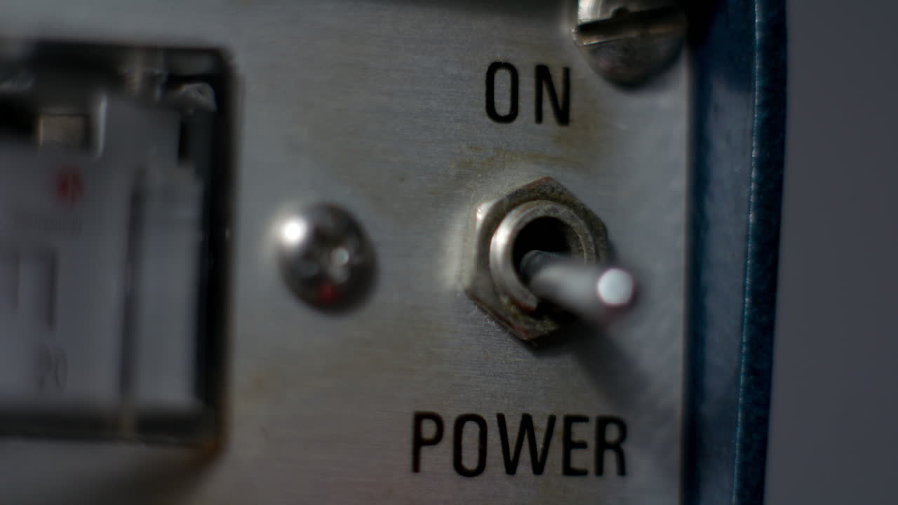 Close-up of a mechanical power switch being turned on on a vintage laboratory power supply, symbolizing activation, control and electrical startup in technical equipment