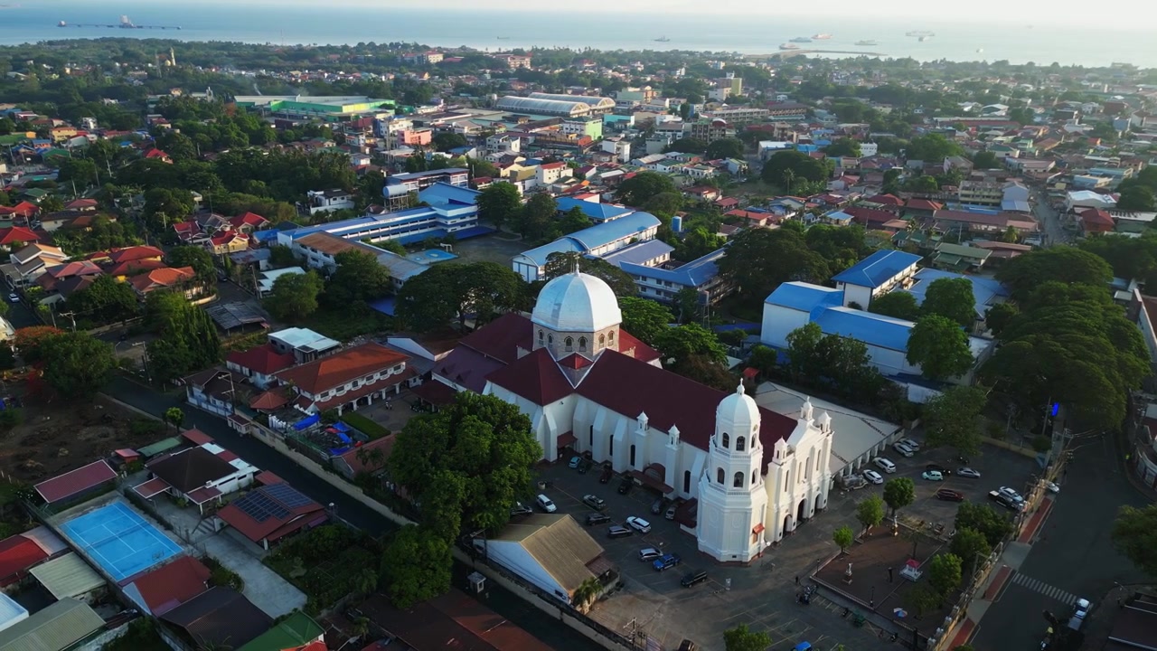 Imagens suaves de drone da Basílica Menor e Paróquia da Imaculada Conceição e do bairro residencial próximo em Batangas, Filipinas, revelando zonas comerciais e comunitárias adjacentes.