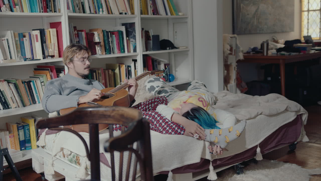 Couple Resting on Bed at Home, Boy Playing the Guitar to Girlfriend