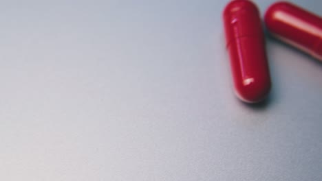 motion along row of red medical capsules on white background