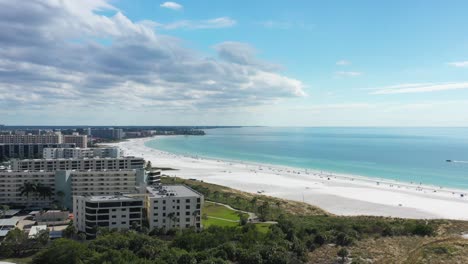 aerial reveal of white sand siesta key beach, florida and beachfront luxury apartments and condominiums