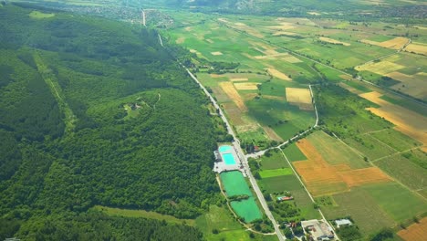 Swimming-pool-near-village,-aerial-view