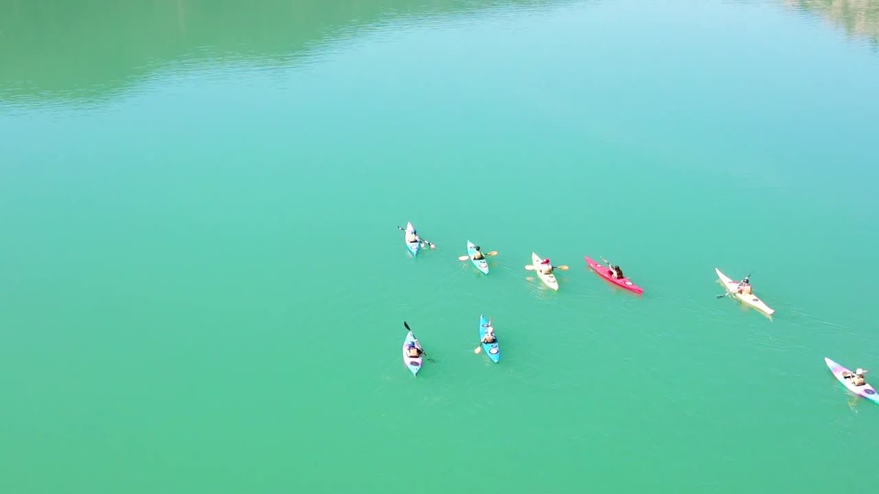 momento divertido jóvenes y adultos remando en kayak en el lago de las montañas de barcelona