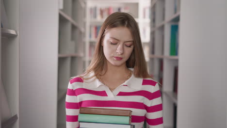 mujer molesta con una pila de libros en el almacén de la universidad. estudiante cansado sostiene literatura para escribir ensayos en la biblioteca pública. trabajo duro en el proyecto de educación