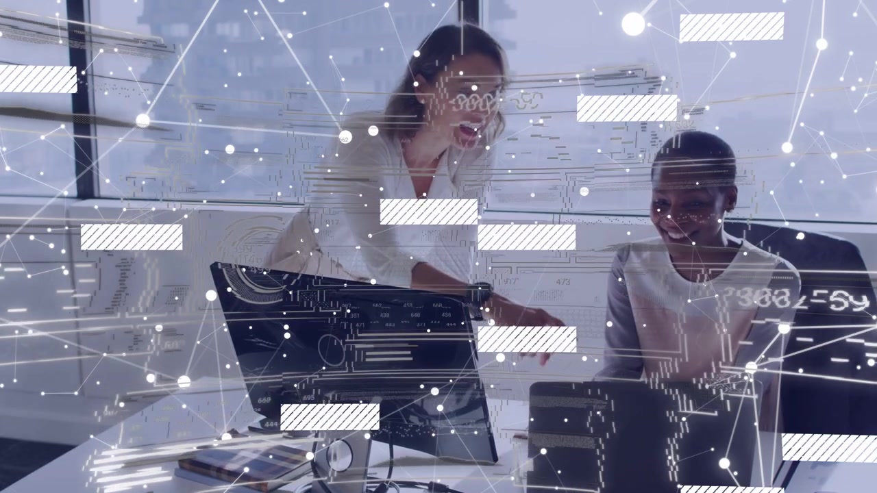 Standing woman mentoring by leaning and pointing at monitors in office in light blouses, HUD