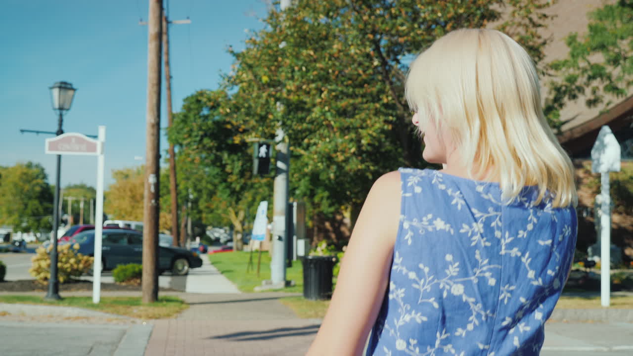 женщина разговаривает по телефону на пешеходном переходе