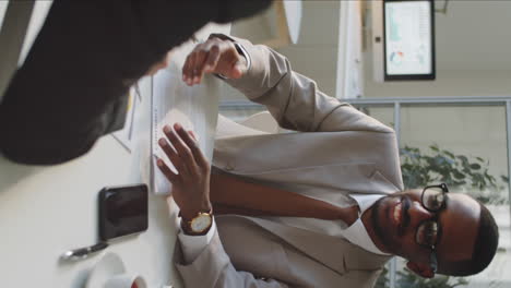 african american businessman giving handshake to partner at office meeting