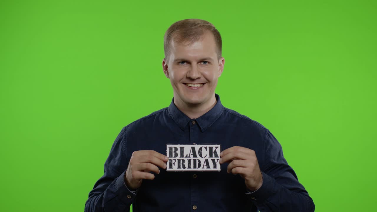 행복한 쇼핑객이 블랙 프라이데이 문자를 보여주며 카메라를 쳐다보며 놀랐다.