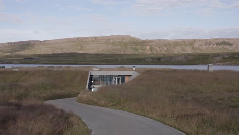 Flying-over-Entrance-lobby-to-Vok-to-reveal-unbelievable-Geothermal-Spa-Baths-floating-in-Lake-Urriðavatn,-Iceland,-Drone-Aerial-Flyover