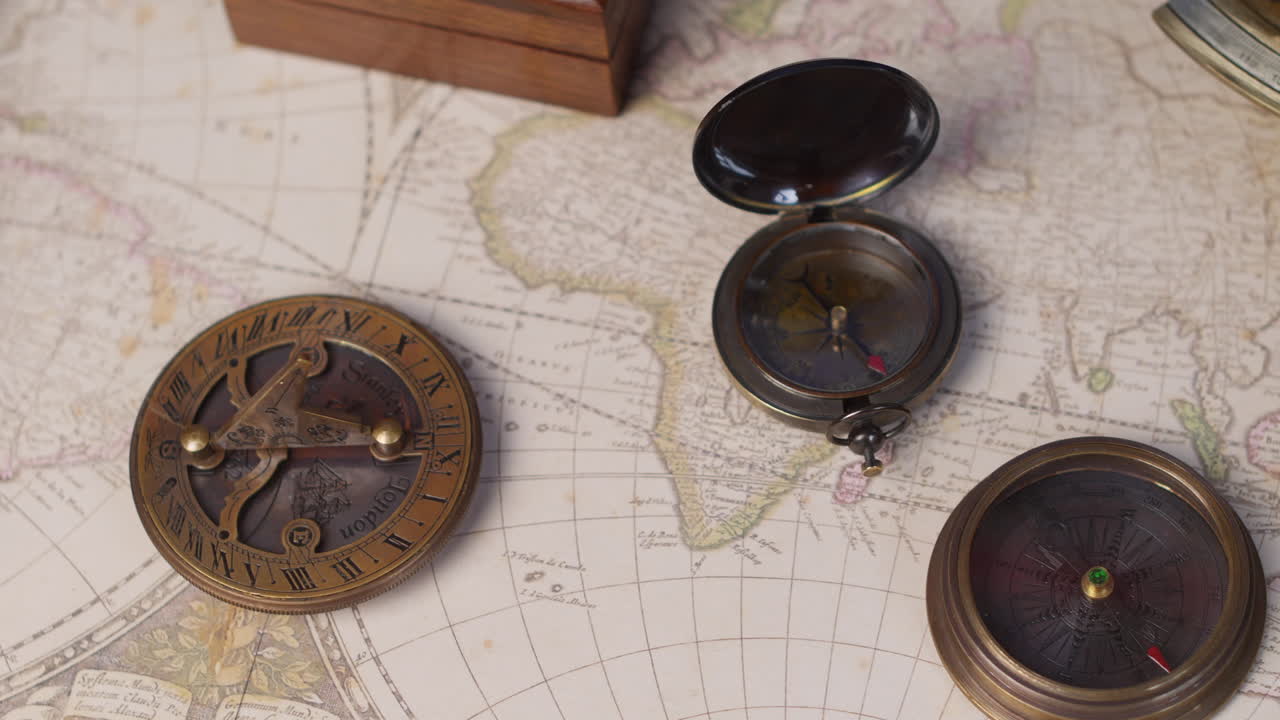 Vintage compass, sundial, telescope and a nautical sextant lying on ancient world map
