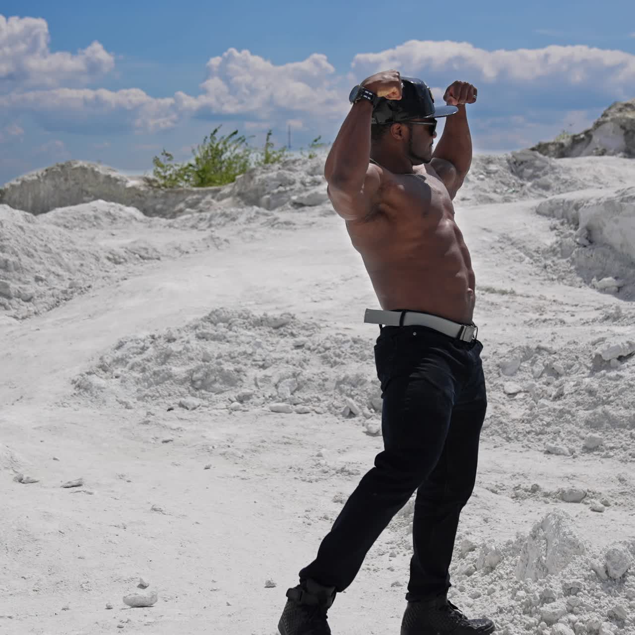 Uomo muscoloso, senza maglietta e di bell'aspetto, in posa per la fotocamera a figura intera. Giovane bodybuilder atletico a torso nudo che mostra i suoi bicipiti