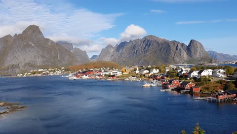 Vista-Sobre-La-Profunda-Bahía-Azul-De-Reine-Con-Impresionantes-Montañas-Escarpadas-De-La-Cadena-Lofoten-En-El-Fondo