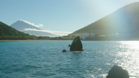 stunning turquoise water of porto pim bay, horta with mount pico in the background