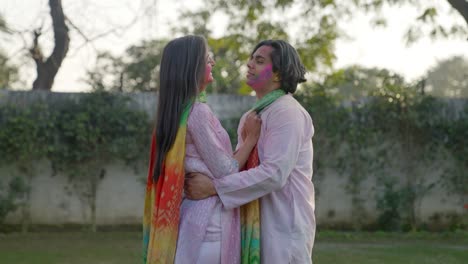 romantic indian couple hugs at a holi party