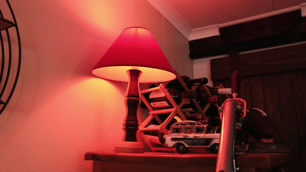 Red light on a cabinet with ornaments and a wine rack in a home