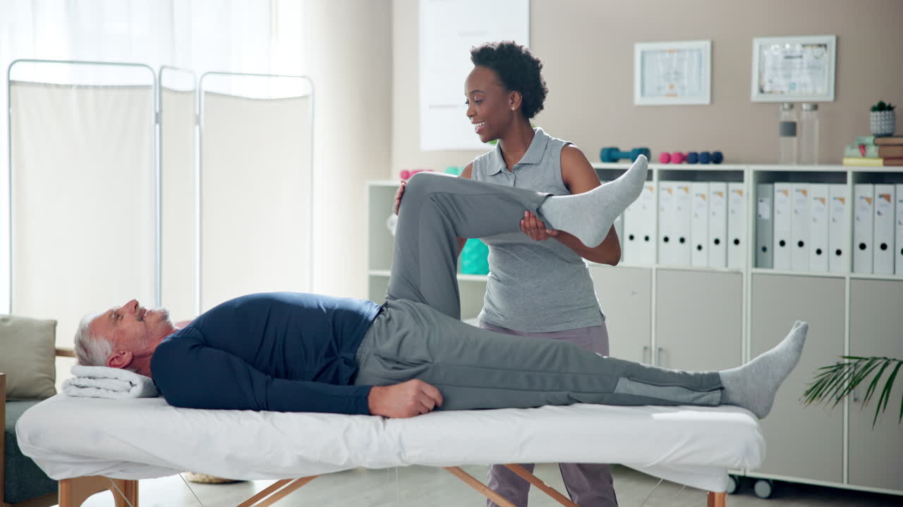 Physical therapist assisting patient with leg exercises