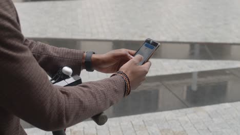 Black-man-is-using-his-phone-for-finding-location-on-map-and-directions