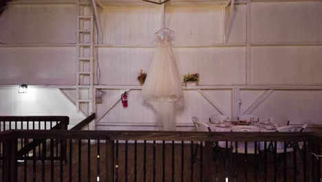 rustic wooden balcony wedding venue with brides dress hanging on display under lantern