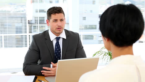 Businessman-interviewing-a-woman-at-his-desk