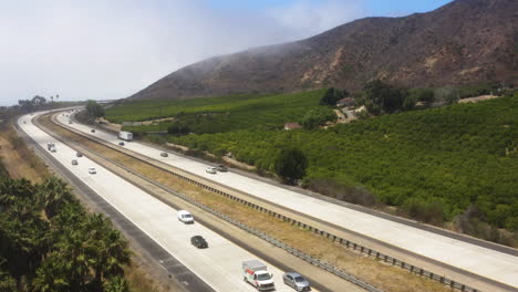 Automóviles-Y-Camiones-Grandes-Que-Recorren-La-Autopista-101,-Sur-De-California,-Rodeados-De-Un-Paisaje-Increíble