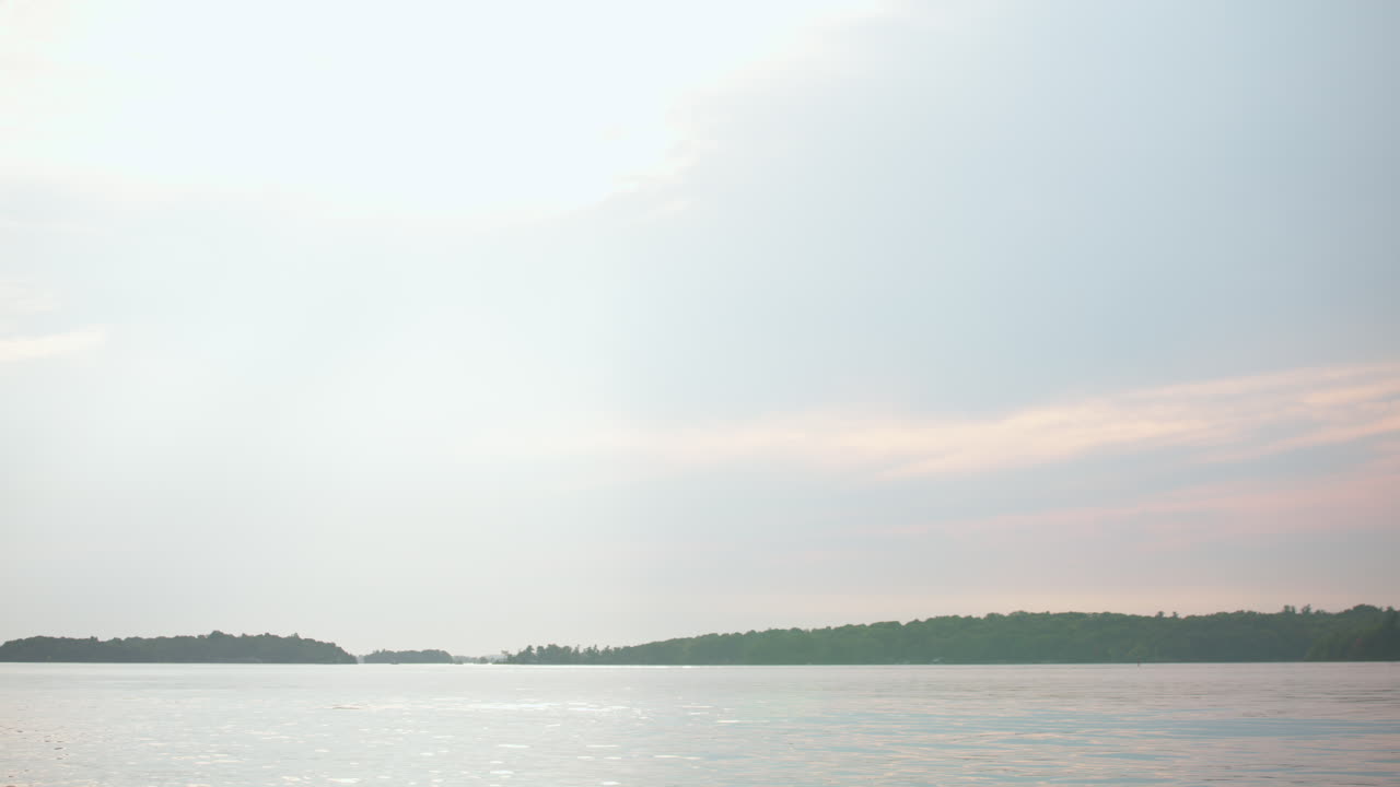 Handheld shot of the St. Lawrence River from Wellesley Island State Park, Fineview, NY. Soft sky tones meet shimmering waters for a tranquil view.