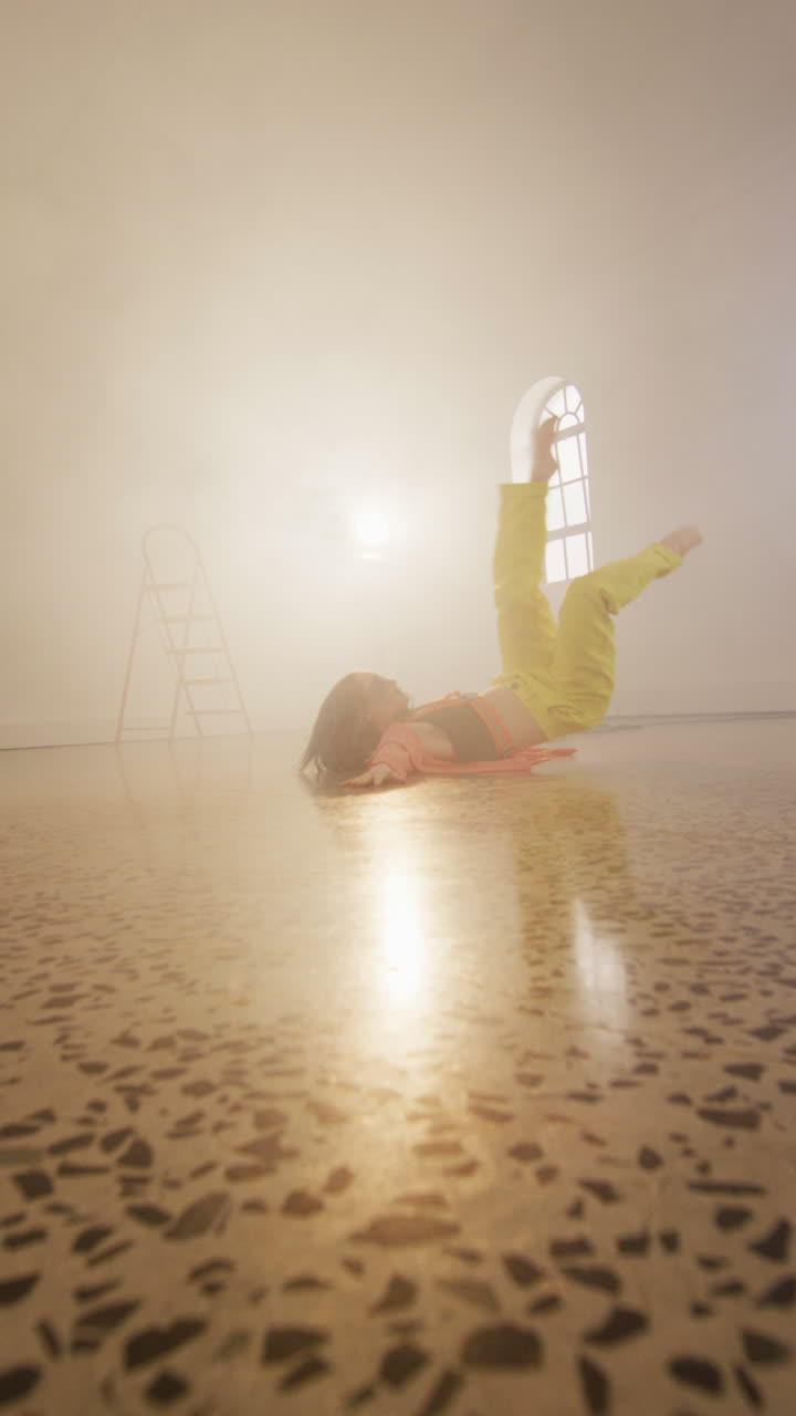 Vertical video of portrait of happy caucasian female dancer dancing in dance studio